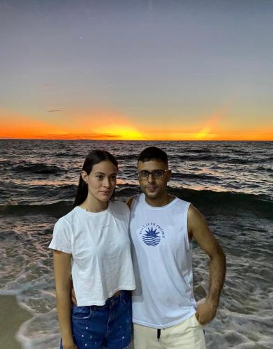 a man and a woman standing on the beach at Hostel bunker Peruano in Playa Blanca