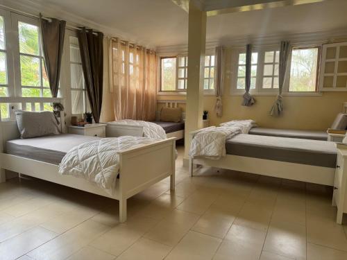 two beds in a room with windows at Villa luxueuse à Skhirat Rabat in Skhirat