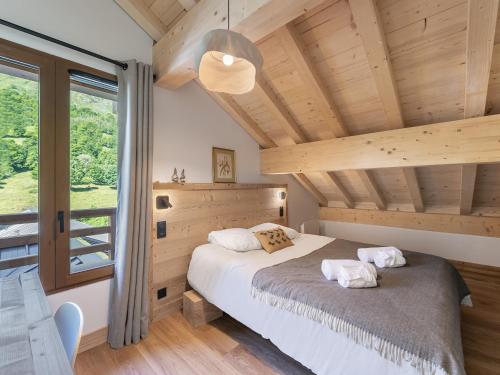 a bedroom with a bed and a large window at Appartement avec terrasse, à 350m des pistes, Le Bettaix - FR-1-570-48 in Praranger