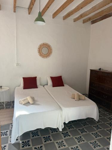 two beds in a room with white walls at Tramuntana home with private pool, Can Canonge in Selva