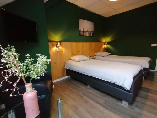 two beds in a room with green walls at Hotel Lemmenhof in Ell