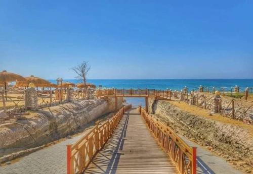 a wooden walkway on the beach with the ocean in the background at Tavera Ras Sudr in Makman