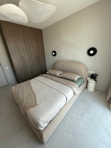 a large bed in a bedroom with a ceiling at Moonlight Apartment - Parko rezidencija SELF CHECK IN in Panevėžys