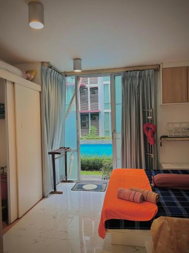 a bedroom with an orange bed and a sliding glass door at Modern Condo with Full Amenities Bangkok in Sathani Ban Hua Mak