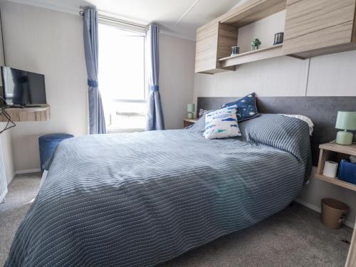 a bedroom with a large bed and a window at V9 Ty Mawr Holiday Park in Abergele