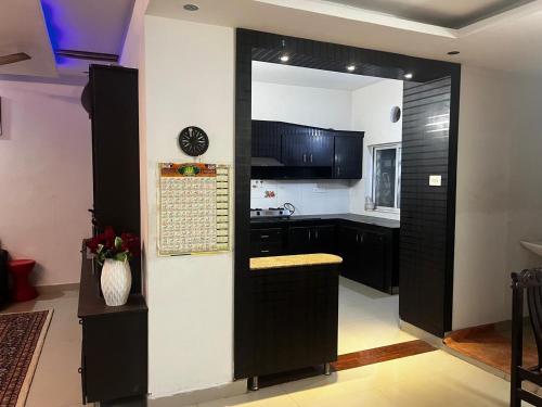 a kitchen with black cabinets and a mirror at Grand City Retreat 4BHK Balcony Bliss in Manikonda in Hyderabad