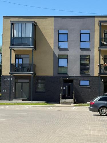 a building with a car parked in front of it at Moonlight Apartment - Parko rezidencija SELF CHECK IN in Panevėžys