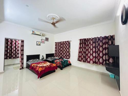 a bedroom with two beds and a ceiling at Grand City Retreat 4BHK Balcony Bliss in Manikonda in Hyderabad