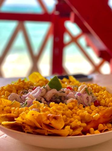 a plate of food with corn on a table at Hostel bunker Peruano in Playa Blanca