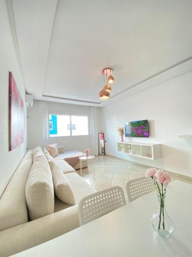 マルティルにあるLayla luxury homeのソファとテーブルのある白いリビングルーム