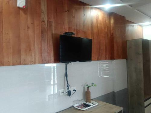 a flat screen tv sitting on top of a wall at Wayanad West Residency in Kalpetta