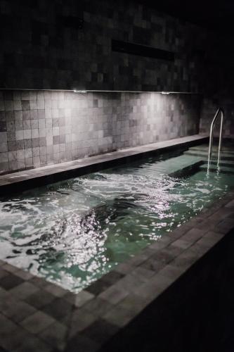 a swimming pool at night with green water at Grand Brizo Bel Air in Buenos Aires