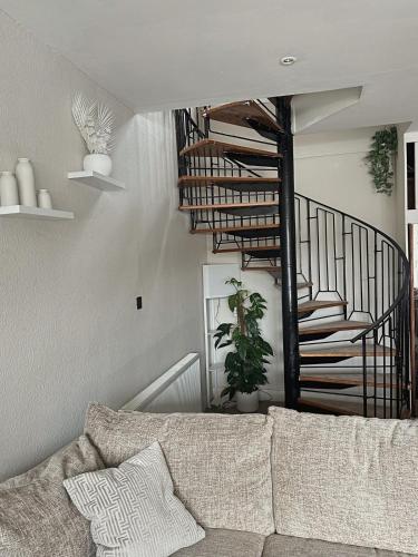 a living room with a couch and a spiral staircase at Duplex - City Centre 4-Bed Retreat in Edinburgh