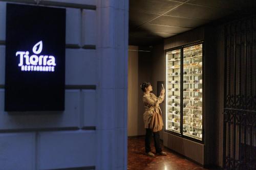 a woman standing in front of a display of wine bottles at Grand Brizo Bel Air in Buenos Aires