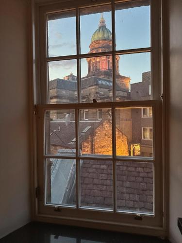 a window with a view of a building at Duplex - City Centre 4-Bed Retreat in Edinburgh