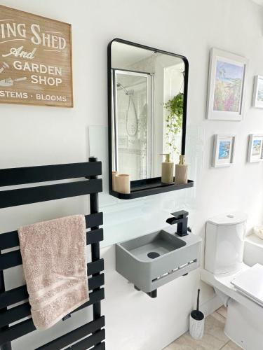 a bathroom with a sink and a mirror at Duplex - City Centre 4-Bed Retreat in Edinburgh