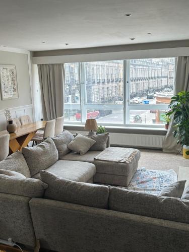 a living room with a couch and a large window at Duplex - City Centre 4-Bed Retreat in Edinburgh