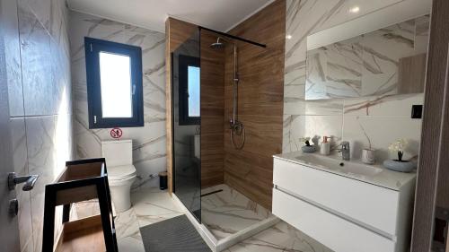 ein Badezimmer mit Dusche, Toilette und Waschbecken in der Unterkunft Olivia Estate South Corfu in Bastátika
