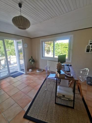 un salon avec une table avec un ordinateur portable dessus dans l'établissement Le Petit Rosnel, à Saint-Jean-de-Monts