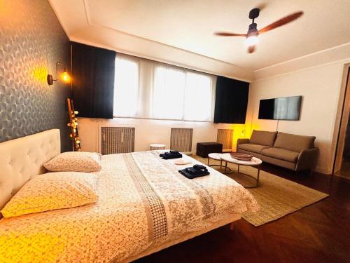 une chambre avec un grand lit et un canapé dans l'établissement Villa Iena 4 étoiles - Centre Ville Perpignan, à Perpignan