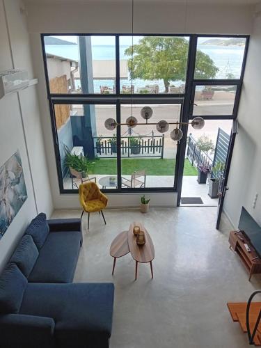 a living room with a blue couch and a table at Loft by the sea in Amfilochía