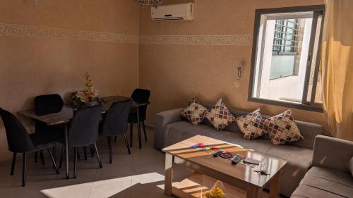 een woonkamer met een bank en een tafel bij Appartement meublée in Kenitra