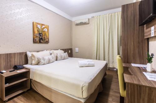 a hotel room with a bed and a desk at Amuarama Hotel in Fortaleza