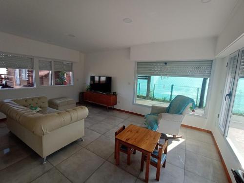 ein Wohnzimmer mit Sofa und Tisch in der Unterkunft Casa Grande para 7 personas in Balneario Claromecó