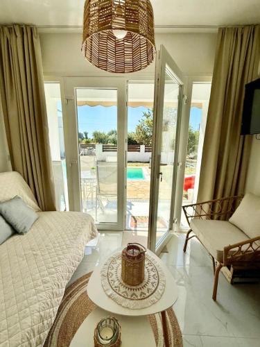 a living room with a bed and a table at Oasis by the Pool in Nea Kallikrateia