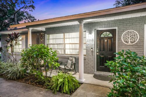 a house with a black door and a chair at Nature Coast Getaway #1 - Cozy 2 Bedroom in Homosassa