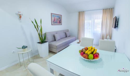 a white living room with a table with a bowl of fruit at Apartment Elle in Čitluk