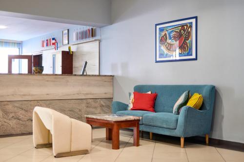a living room with a blue chair and a table at Hotel Selce in Selce