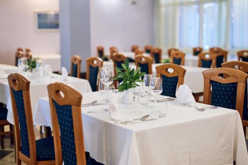 a dining room with tables and chairs with white table cloth at Hotel Selce in Selce