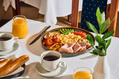 a table topped with a plate of food and coffee at Hotel Selce in Selce