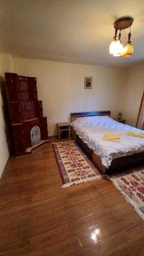 a bedroom with a bed and two rugs on the floor at Casa Damian in Bertea