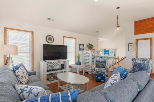 una sala de estar con un sofá y una mesa en Flip Flop Inn by Village Realty, en Nags Head