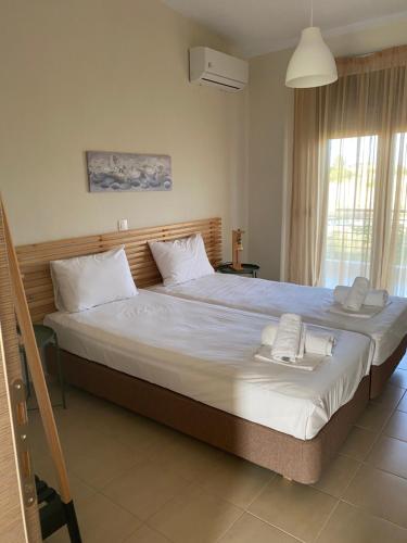 a bedroom with a large bed with two towels on it at ALKYONI HOUSE IN AFYTOS in Afitos