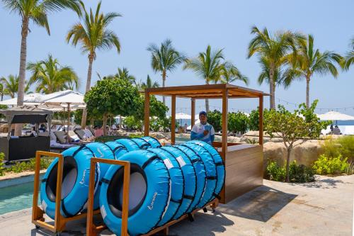 a man sitting on a water slide at a resort at Villa La Valencia Beach Resort & Spa Los Cabos in San José del Cabo
