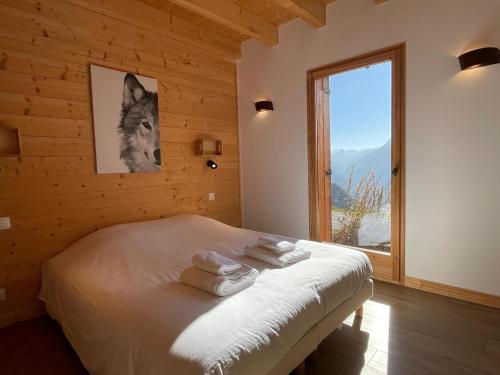- une chambre avec un lit, des serviettes et une fenêtre dans l'établissement Chalet 12 pers, jacuzzi, sauna, ski-in, La Rosière - FR-1-690-27, à Montvalezan