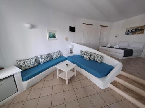 ein Wohnzimmer mit einem großen Bett und einem Sofa in der Unterkunft Solaris in Folegandros Chora