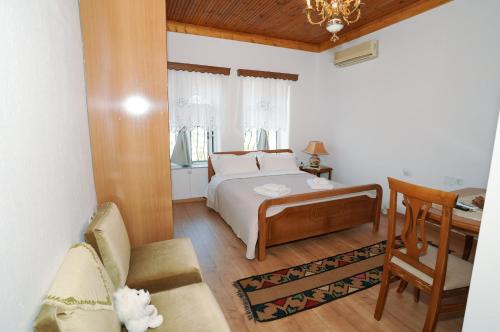 a bedroom with a bed and a desk and a chair at Amalia's House in Gjirokastër