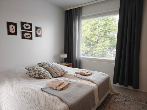 a bedroom with a bed with two towels on it at Kampuksen Hertta in Pori