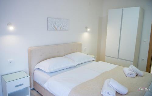 a bedroom with a white bed with two towels on it at Apartment Elle in Čitluk