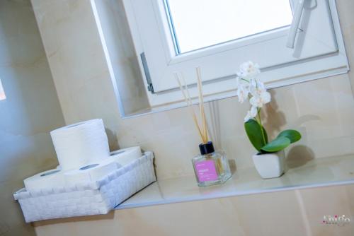 a bathroom shelf with toilet paper and a window at Apartment Elle in Čitluk