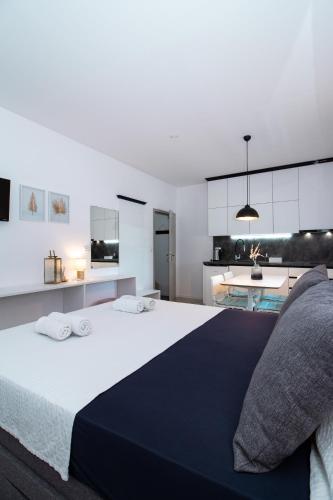 a bedroom with a large bed and a kitchen at Studioapartment Black & White in Velika Gorica