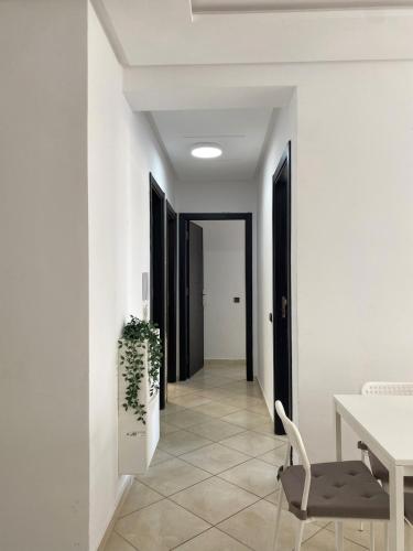 a white hallway with a table and a chair at Shams luxury home in Martil