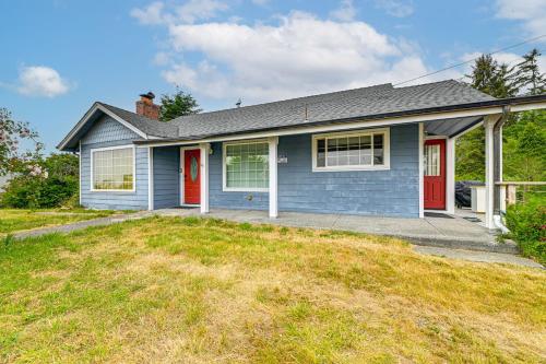 a blue house with red doors and a yard at Walk to Beach Cozy Home with Deck in Smith River! in Smith River