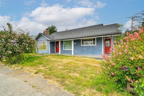 a blue house with a red door and some flowers at Walk to Beach Cozy Home with Deck in Smith River! in Smith River