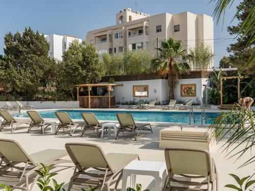 a swimming pool with chairs and a hotel at Vago Ibiza in San Antonio Bay