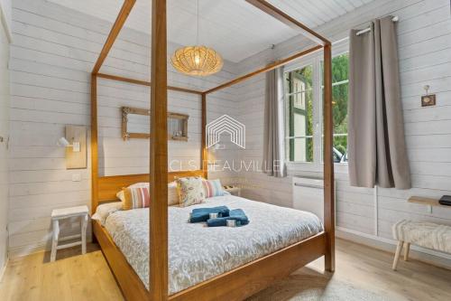 a canopy bed in a bedroom with a window at Bois Corail Maison de vacances jardin, vue mer & Spa in Trouville-sur-Mer